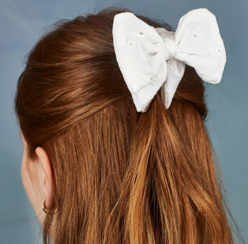 model wearing white eyelet bow clip in half up half down hair