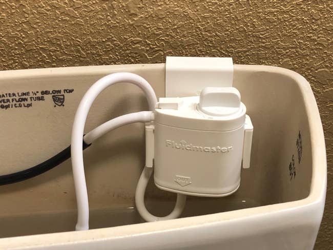 reviewer image of the cartridge hanging inside of a toilet's tank