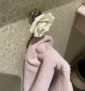 towel hangs from white rose hook 