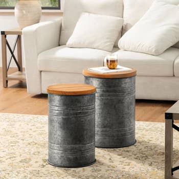 Two metal stools in front of a couch holding a drink