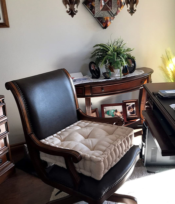 reviewer photo of the beige pillow on a desk chair