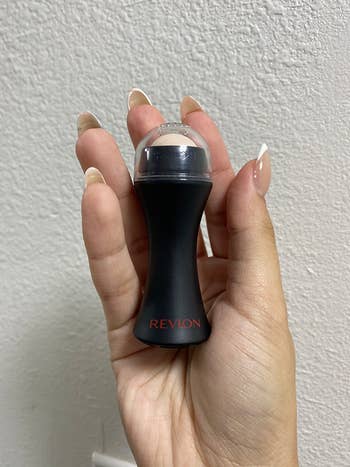 Reviewer holding face roller in hand