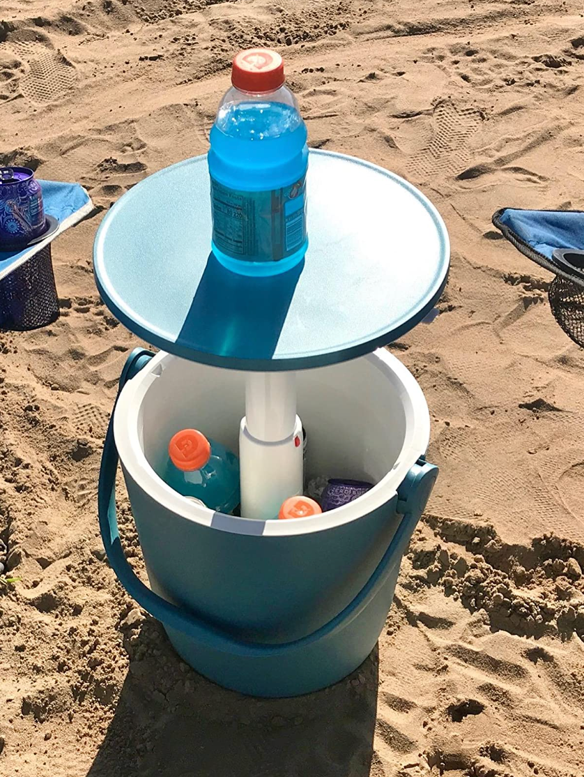 A small blue cooler with Gatorades inside that has the top lifted off to become a small table 