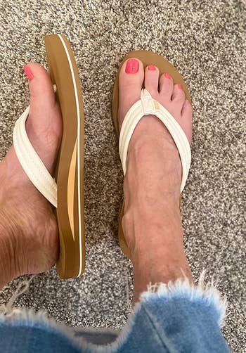 reviewer wearing the white flip-flops and showing a side view of one