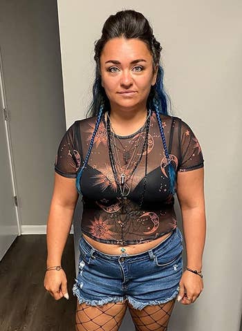 reviewer wearing a black sheer top with a black bra underneath