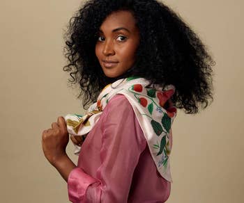 model wearing the light pink floral scarf tied around their neck