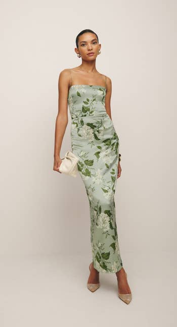 Model in a floral slip dress posing with a clutch, ideal for spring shopping inspiration