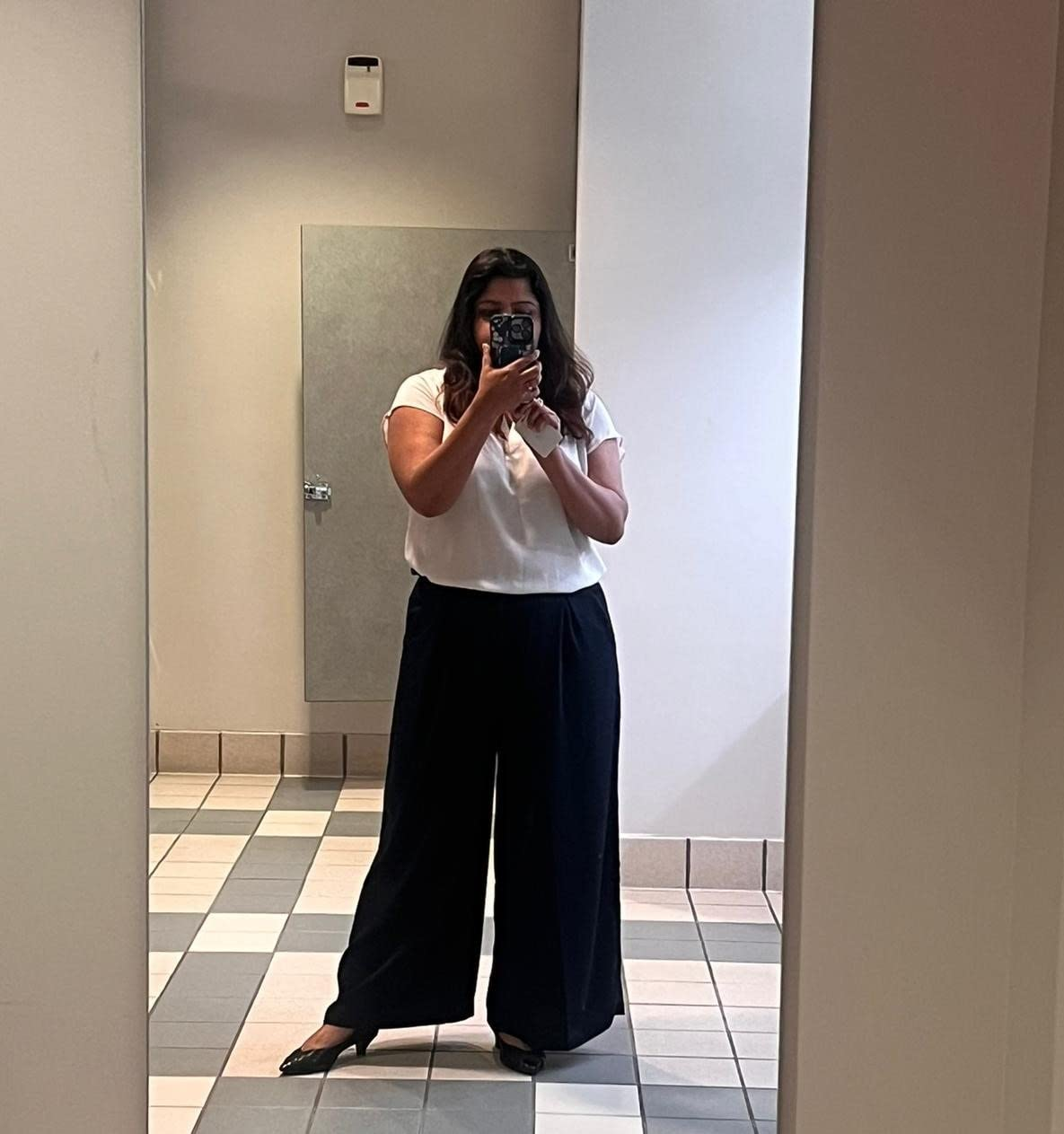 Reviewer wearing wide-leg trousers and a white blouse