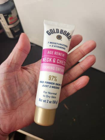 Person holding a conduit of Gold Bond Age Renew Neck & Chest Firming Cream