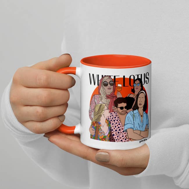 hand holding mug with illustrations of the characters and text 