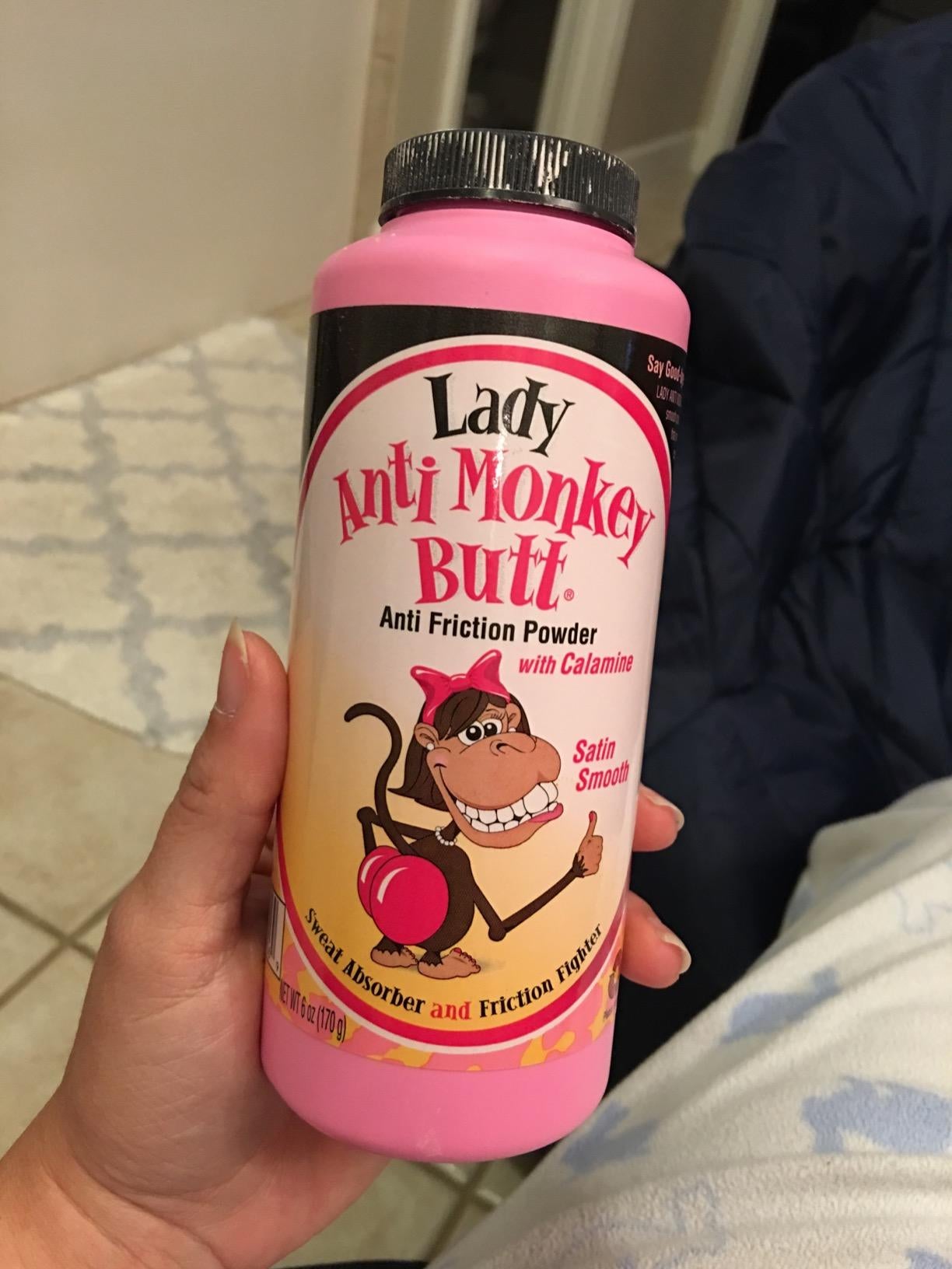 reviewer holding a pink bottle with a cartoon monkey on it that's giving a thumbs up