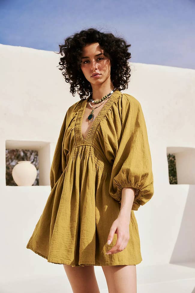 model posing in olive green deep V-neck mini dress