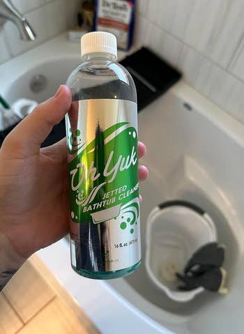 image of reviewer's hand holding the bottle of tub cleaner