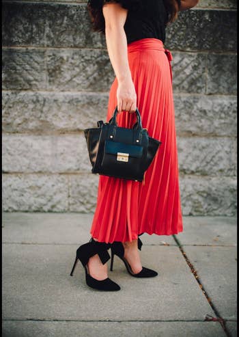 Reviewer in heels zoomed out to show red skirt accessorized with them 