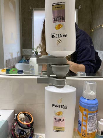 reviewer photo of the bottle emptying kit being used to transfer the contents of one bottle to another