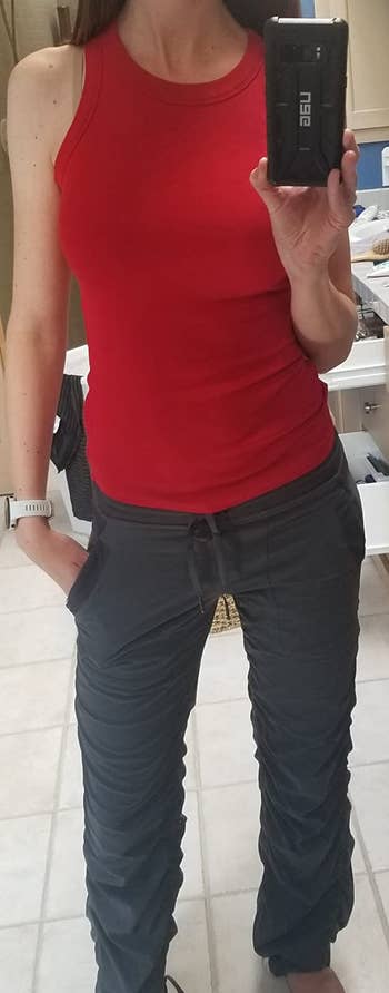 reviewer wearing the red tank with jogging bottoms