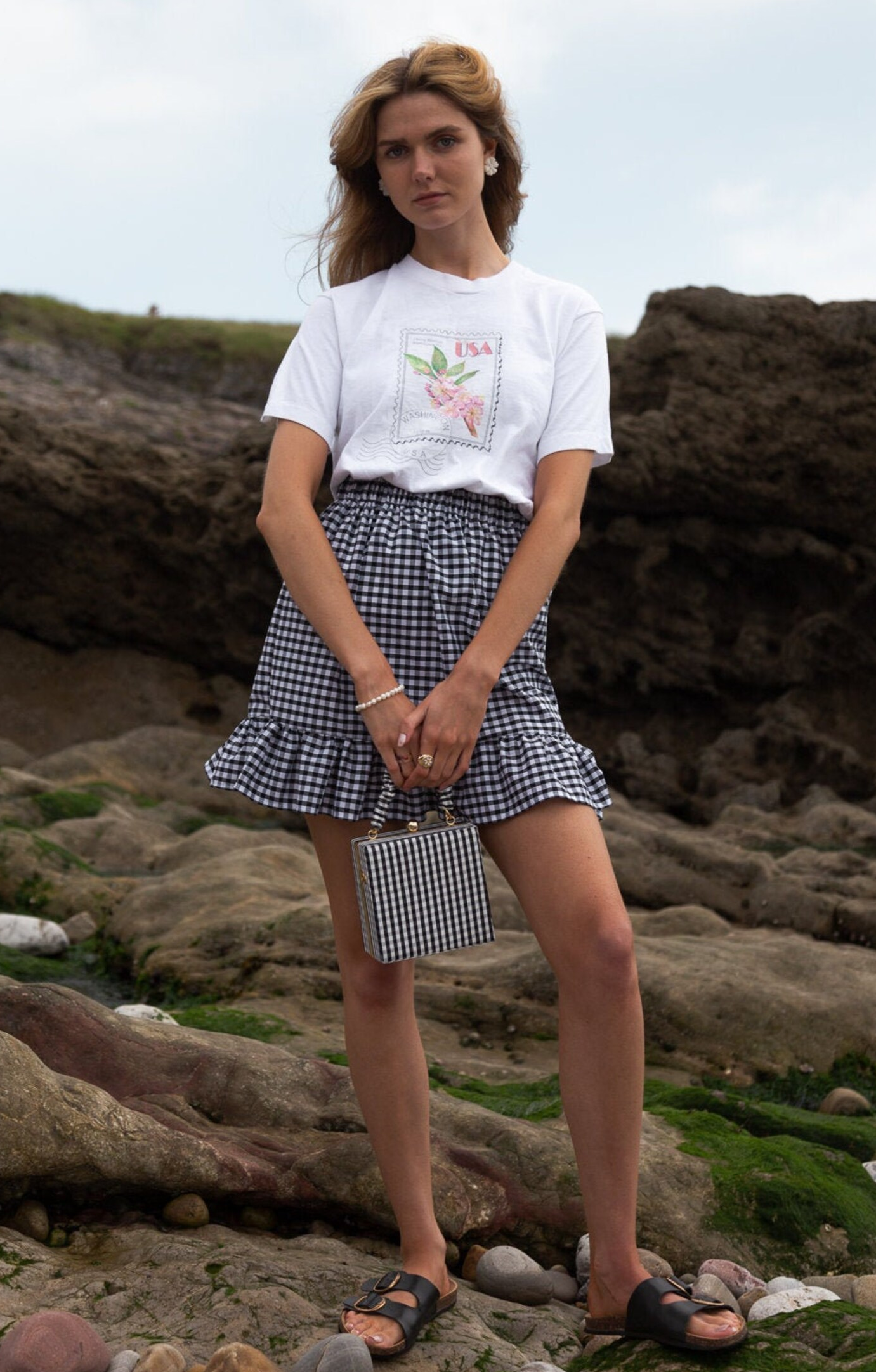 a model wearing a gingham-print mini skirt with a ruffle hem paired with a white T-shirt 