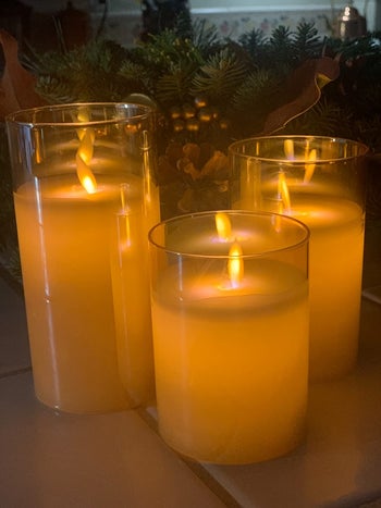a set of three flameless candles in clear glass cylinders