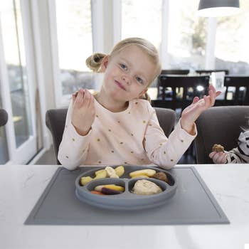 a kid eating a meal using the ez pz mat plate