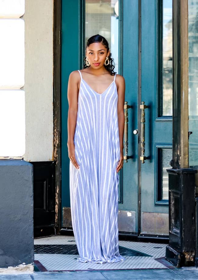 a model in a long blue maxi dress with vertical white stripes
