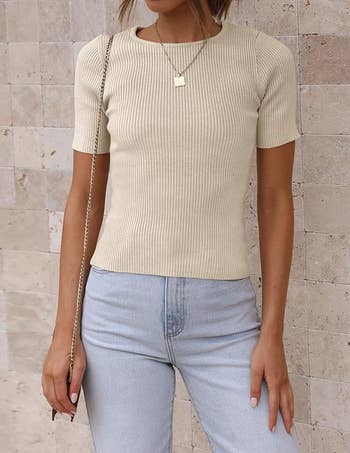 model in a ribbed short-sleeve top and light-wash jeans