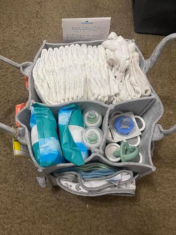 a reviewer's diaper caddy with a clump  of worldly   showing antithetic  compartments 