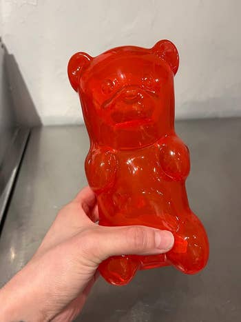 reviewer holding their red gummy bear lamp