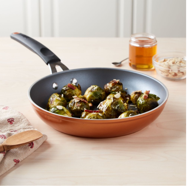 An orange pan with brussel sprouts cooking in it