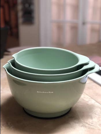 Three stacked light green mixing bowls