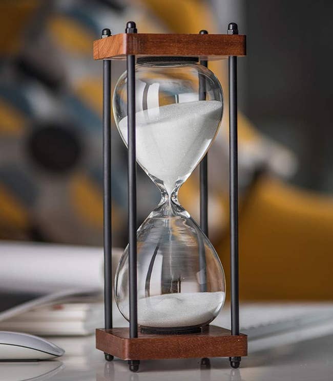 Hourglass on a table with white sand inside