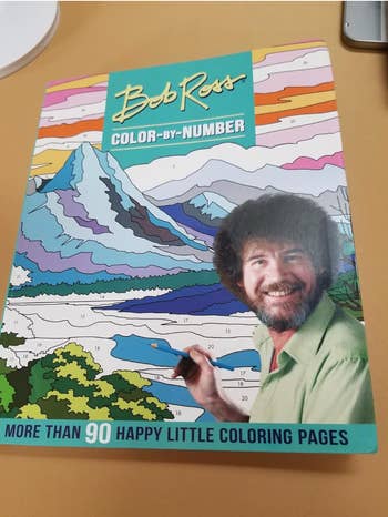Bob Ross Color-by-Number publication  connected  a table, featuring implicit    90 coloring pages and an representation  of Bob Ross with a paintbrush
