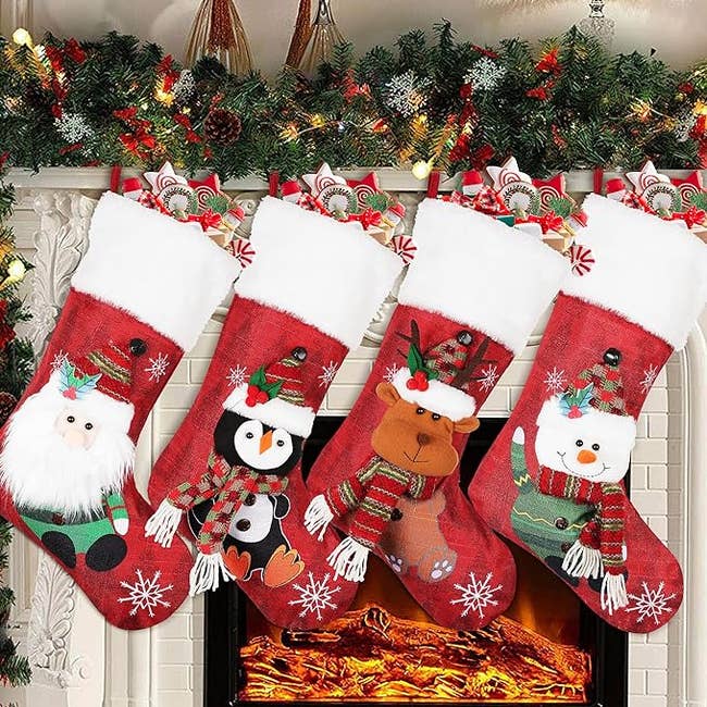 The four red stocking with santa, a penguin, a reindeer, and a snowman on them