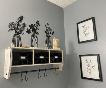 reviewer pic of the sculptures mounted above a bookshelf so it looks like they're sitting on the top of the shelf