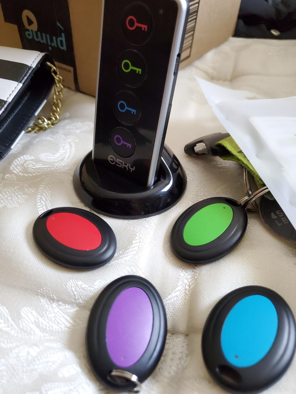 a reviewer photo of the four trackers and finder remote