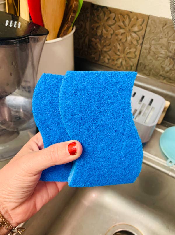 reviewer holding two sponges above sink