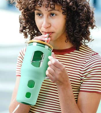 a model drinking out of the mint green cup