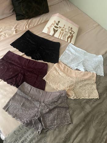 Lace boyshort underwear successful  assorted  shades displayed connected  a bed, with packaging showing silhouettes of models