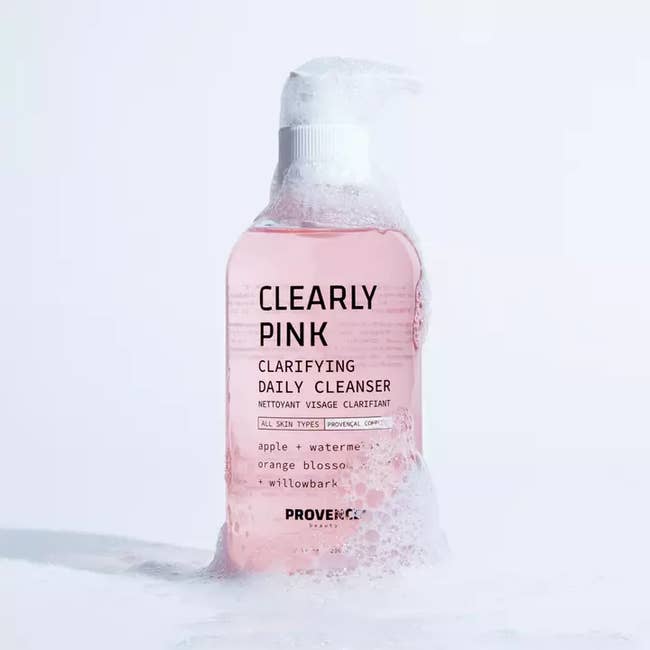 a pink glass bottle of clarifying daily cleanser