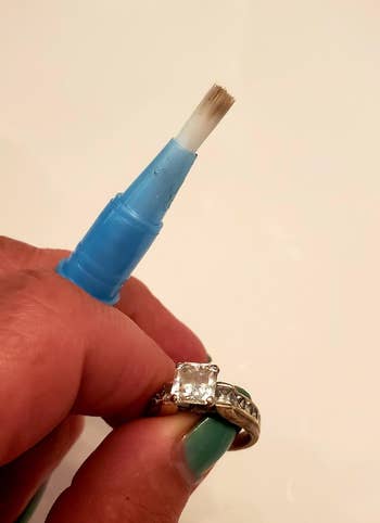 網路行銷 reviewer holding jewelry pen and a sparkly ring they cleaned with it