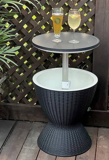reviewers black table lifted up showing the cooler compartment with two drinks on the tabletop