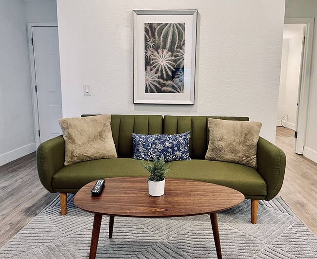 a reviewer's walnut coffee table in front of a green couch