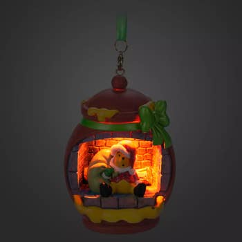 a honey pot-shaped ornament with pooh inside of it dressed as santa