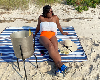 a reviewer sitting on the blanket on the beach