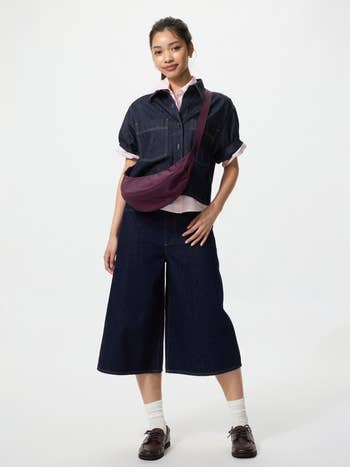 Person successful casual denim outfit with wide-leg pants and a casual top, wearing a crossbody bag