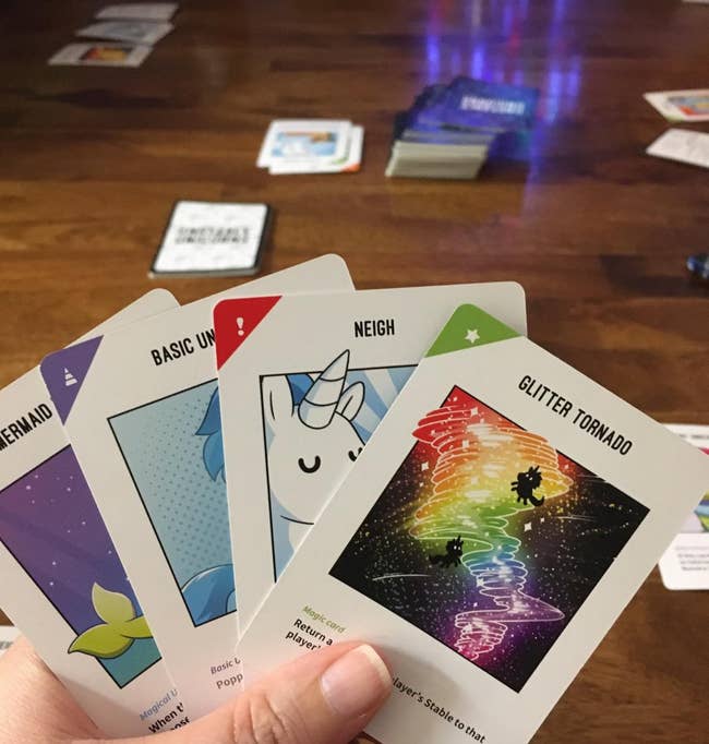 a reviewer's hand of unstable unicorn cards