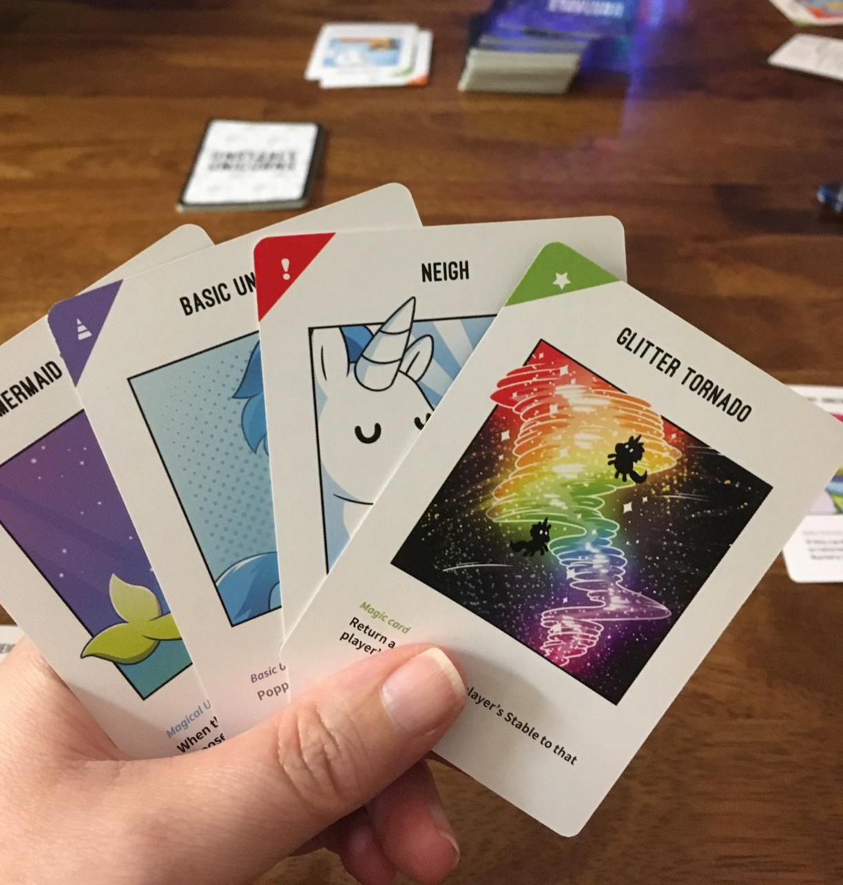 a reviewer's hand of unstable unicorn cards