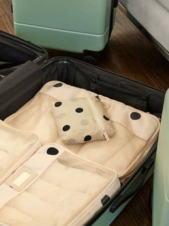 Open suitcase with a polka-dotted pouch on it