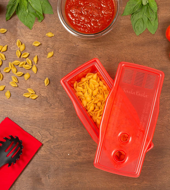 the red pasta maker holding uncooked pasta