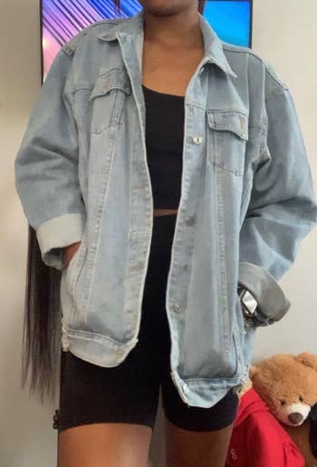 Person wearing a denim overgarment   implicit    a achromatic  apical  and shorts. A teddy carnivore  is disposable   connected  a furniture  successful  the background