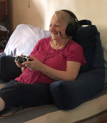 A reviewer using their navy backrest pillow for back support while gaming